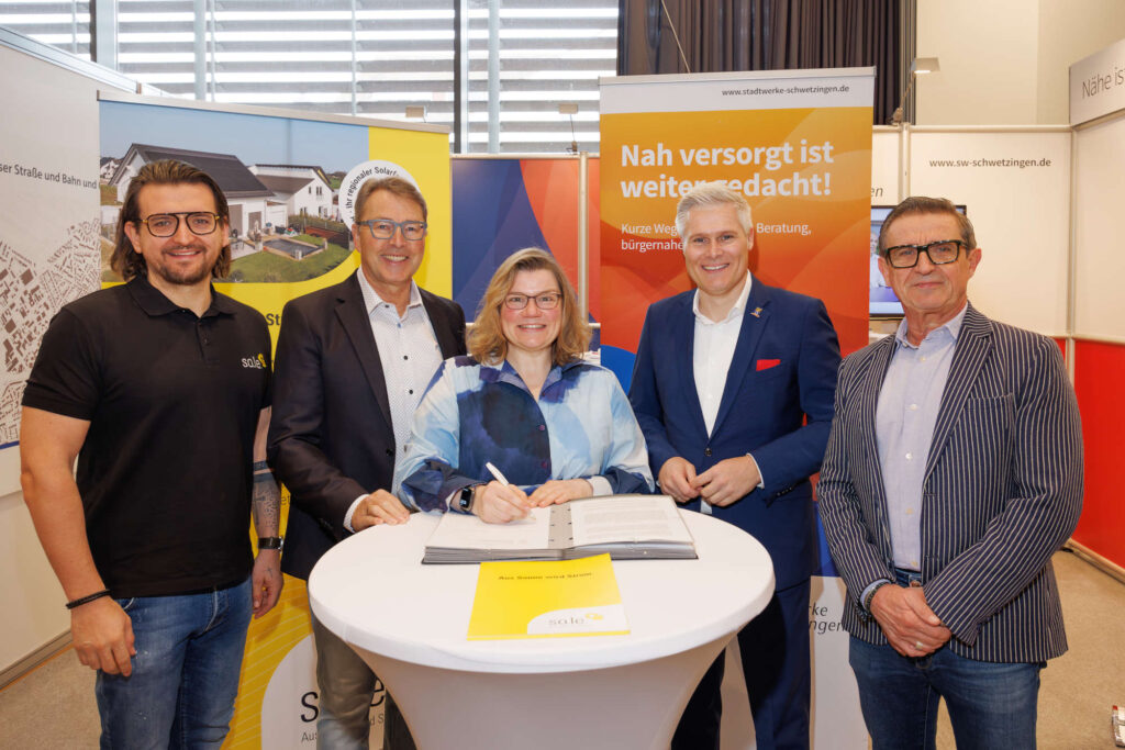 Martina Braun, Jürgen Schmitt und Oberbürgermeister Matthias Steffan unterzeichnen gemeinsam mit Marcel Lehmayer und Rudi Lehmayer den Vertrag zur Erweiterung der PV-Anlagen auf den Dächern des Hebel-Gymnasiums und der Schimper-Gemeinschaftsschule